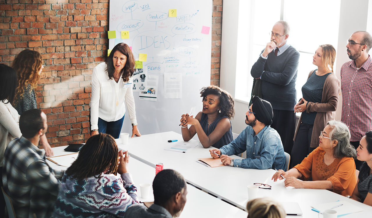 Handle projects and teams of any size Image of a team in a meeting