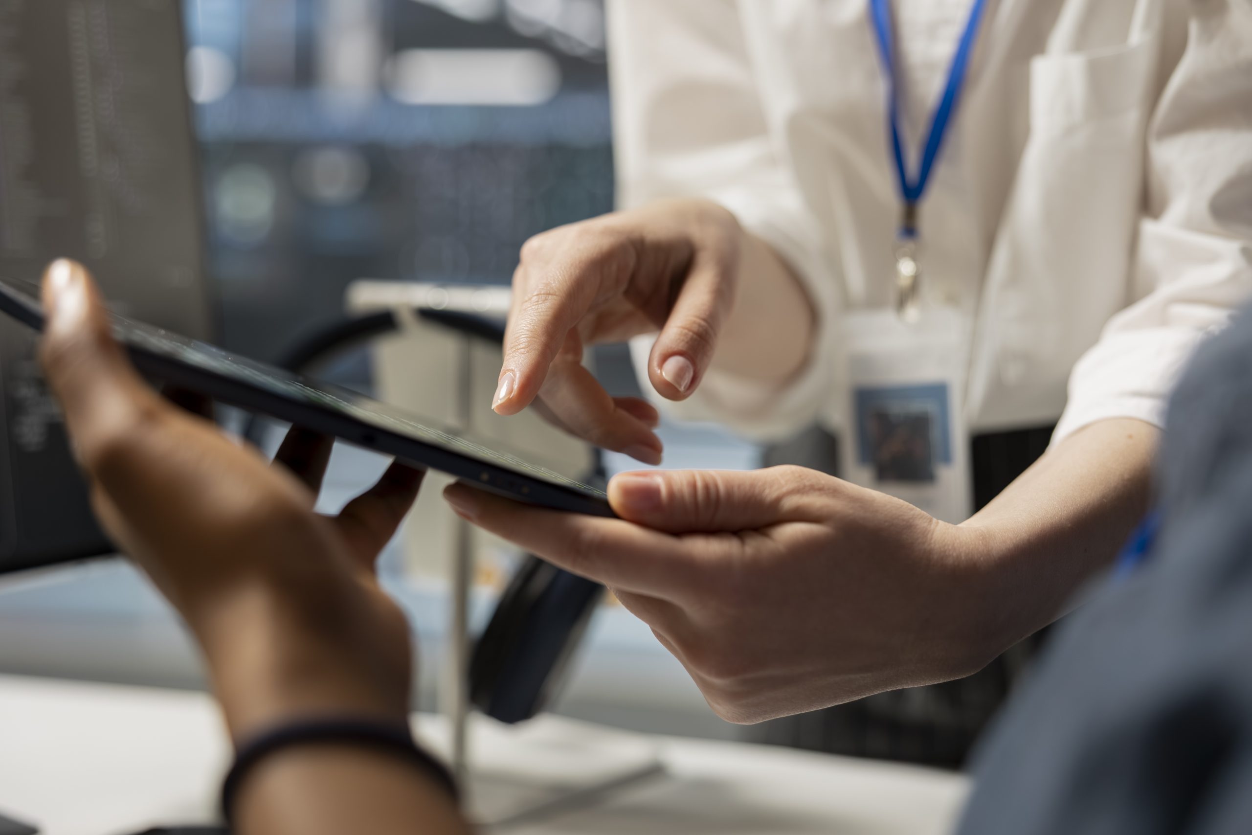 Data center engineering team analyzing software logs metrics on tablet, optimizing storage systems. Close up of server farm coworkers inspecting resource utilization on device